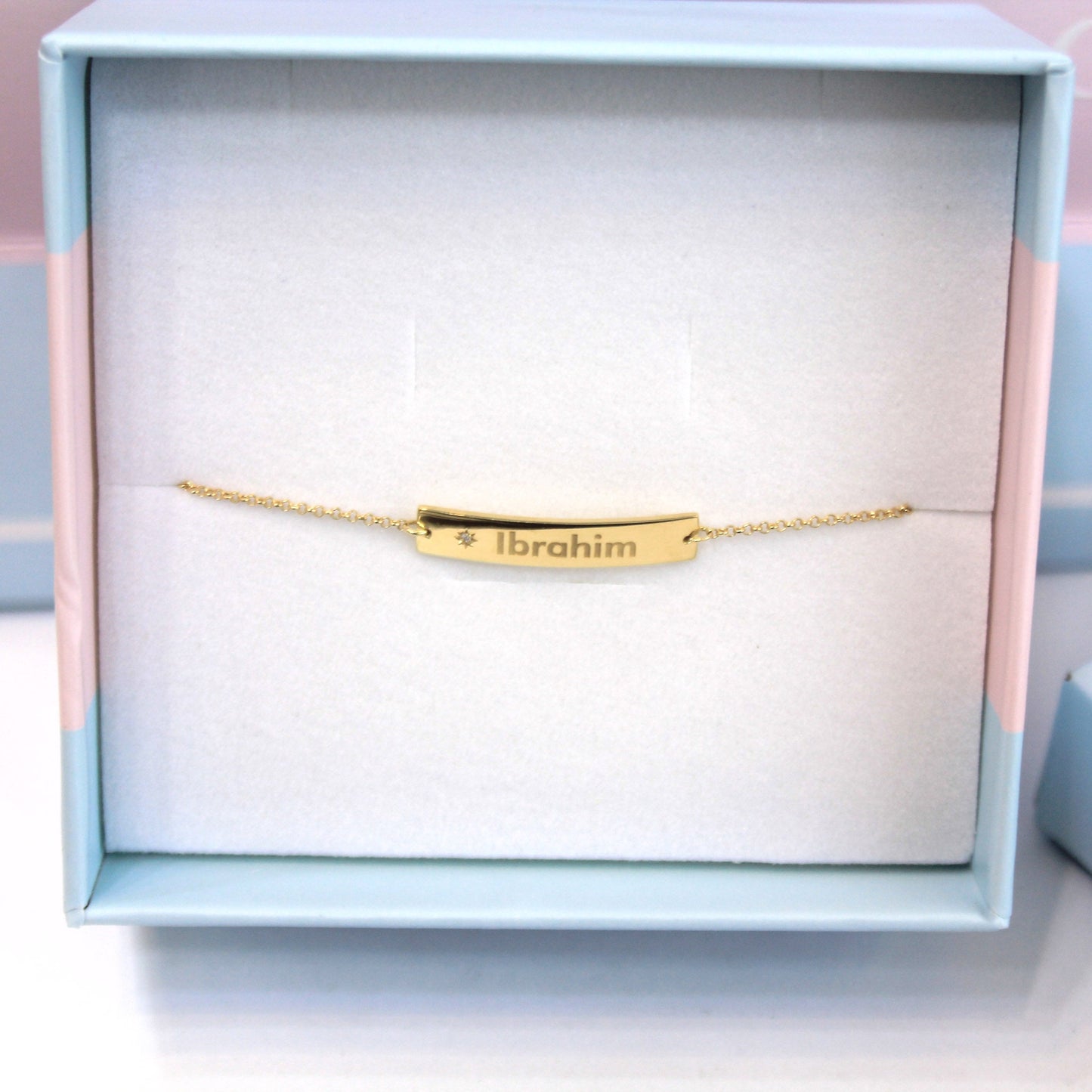 Gold inscription diamond bracelet with engraved name and star detail.