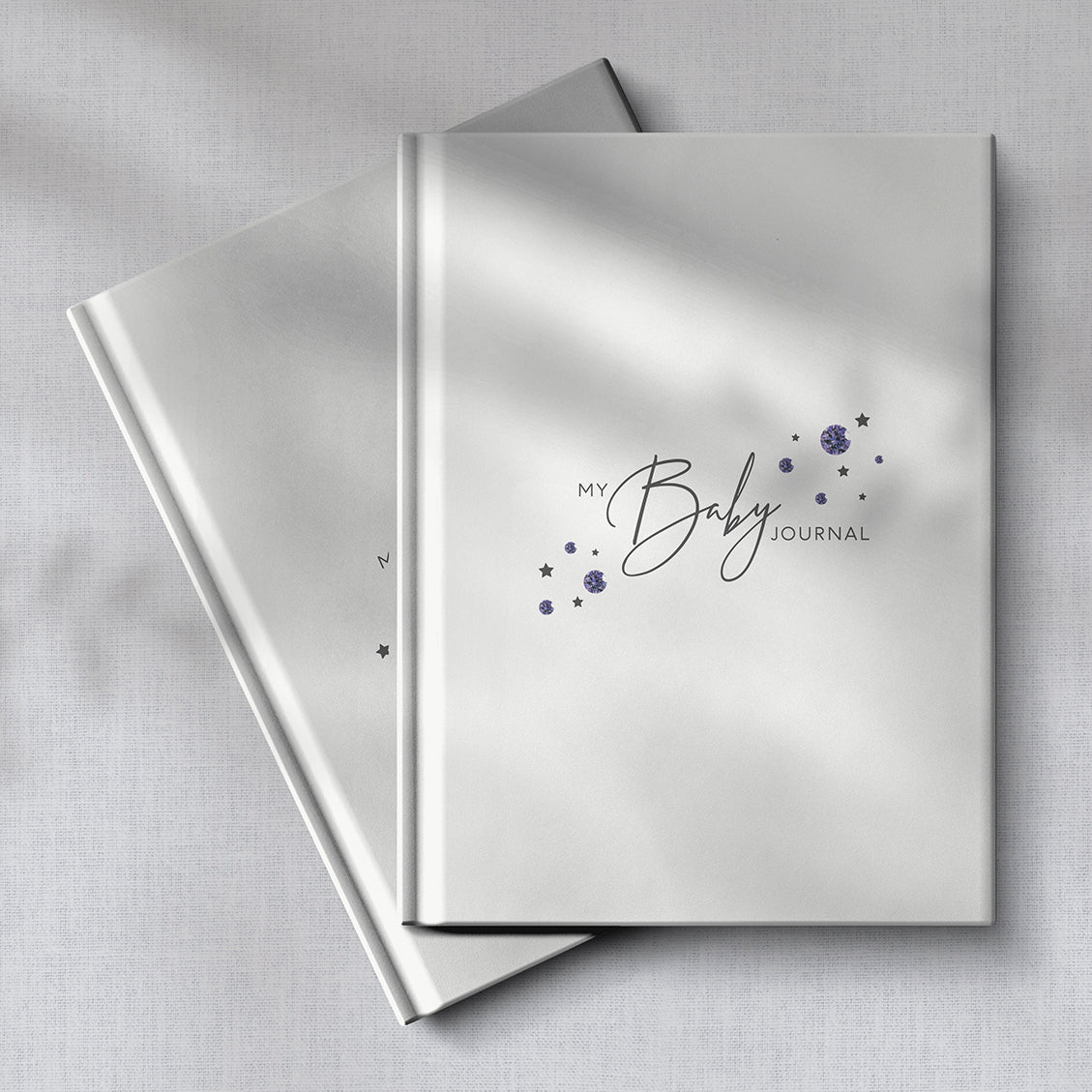 Two amethyst baby journals with soft fabric background.