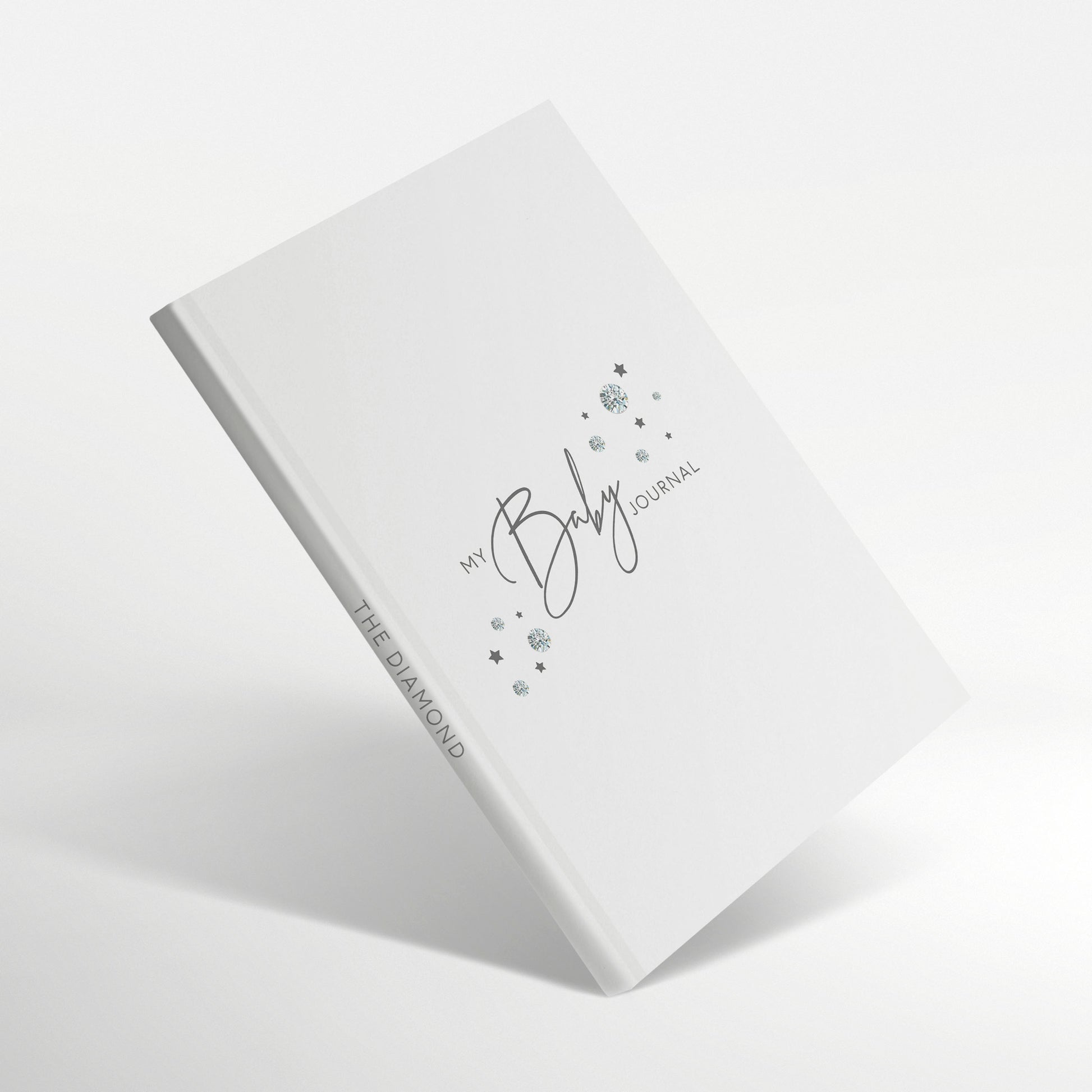 White baby journal with diamond-inspired gemstones on the cover.
