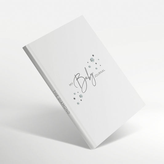 White baby journal with diamond-inspired gemstones on the cover.