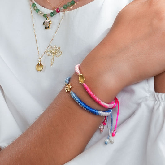 Close-up of a wrist wearing colorful BabyChic bracelets with a white background