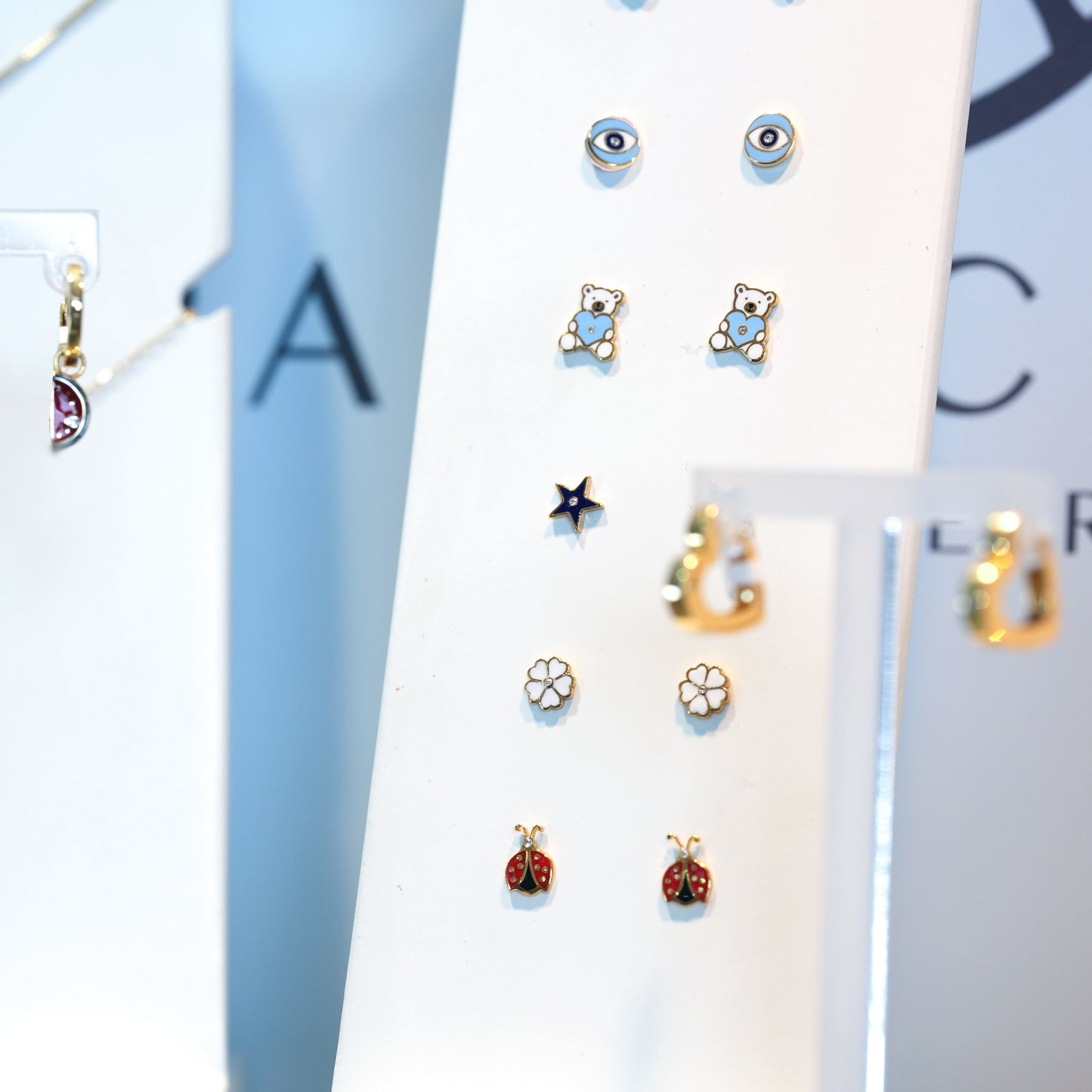 Collection of small earrings on a display card with a blurred background