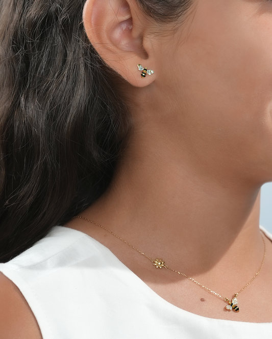 18K gold bee stud earring with diamond wings and daisy necklace on model