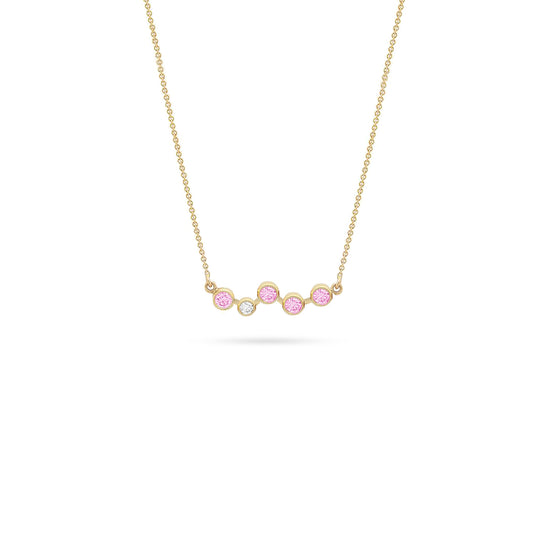Gold necklace featuring a row of bezel-set round stones—five pink and one white diamond—arranged in a gentle curve, displayed on a white background.