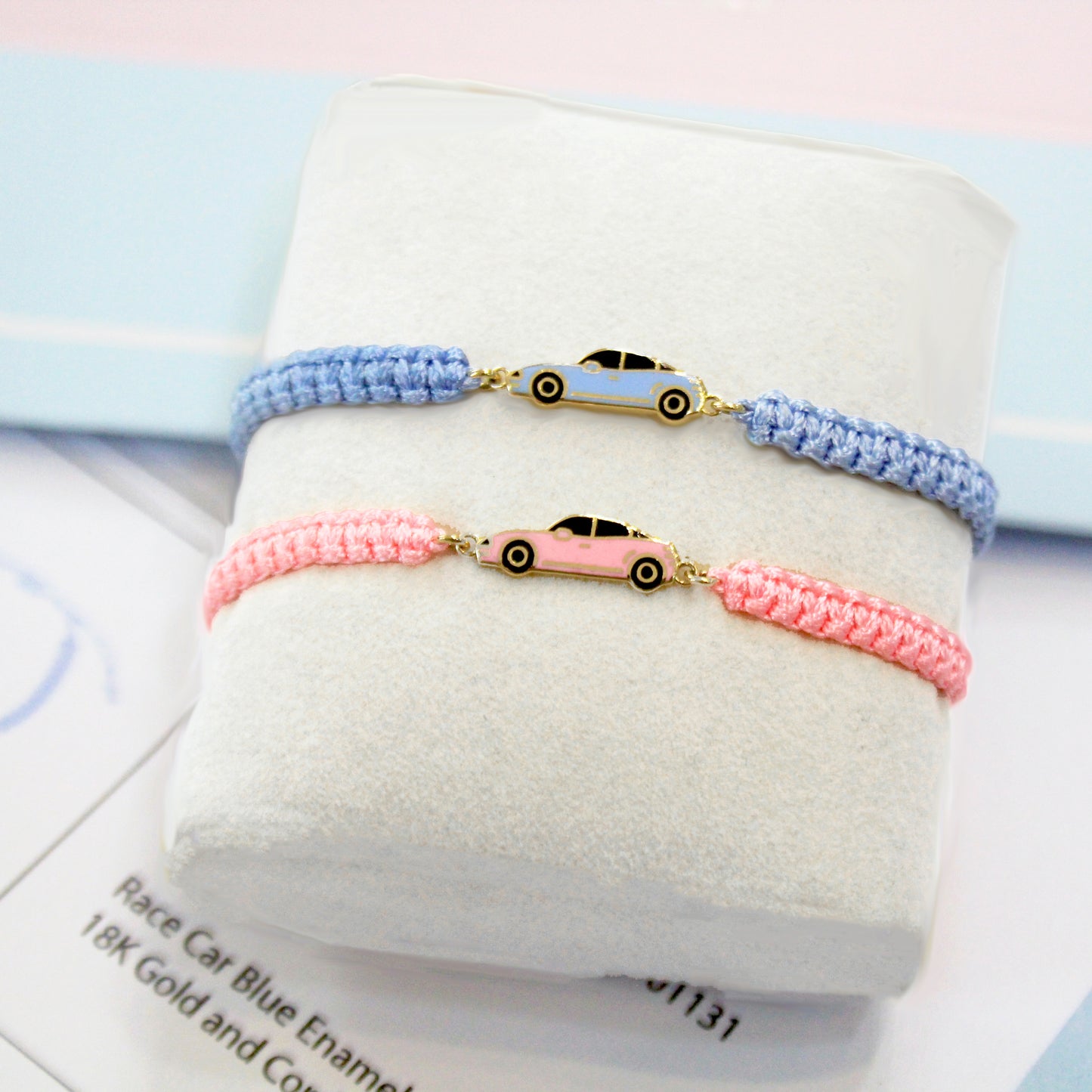 Blue and pink cord bracelets with gold car charms displayed