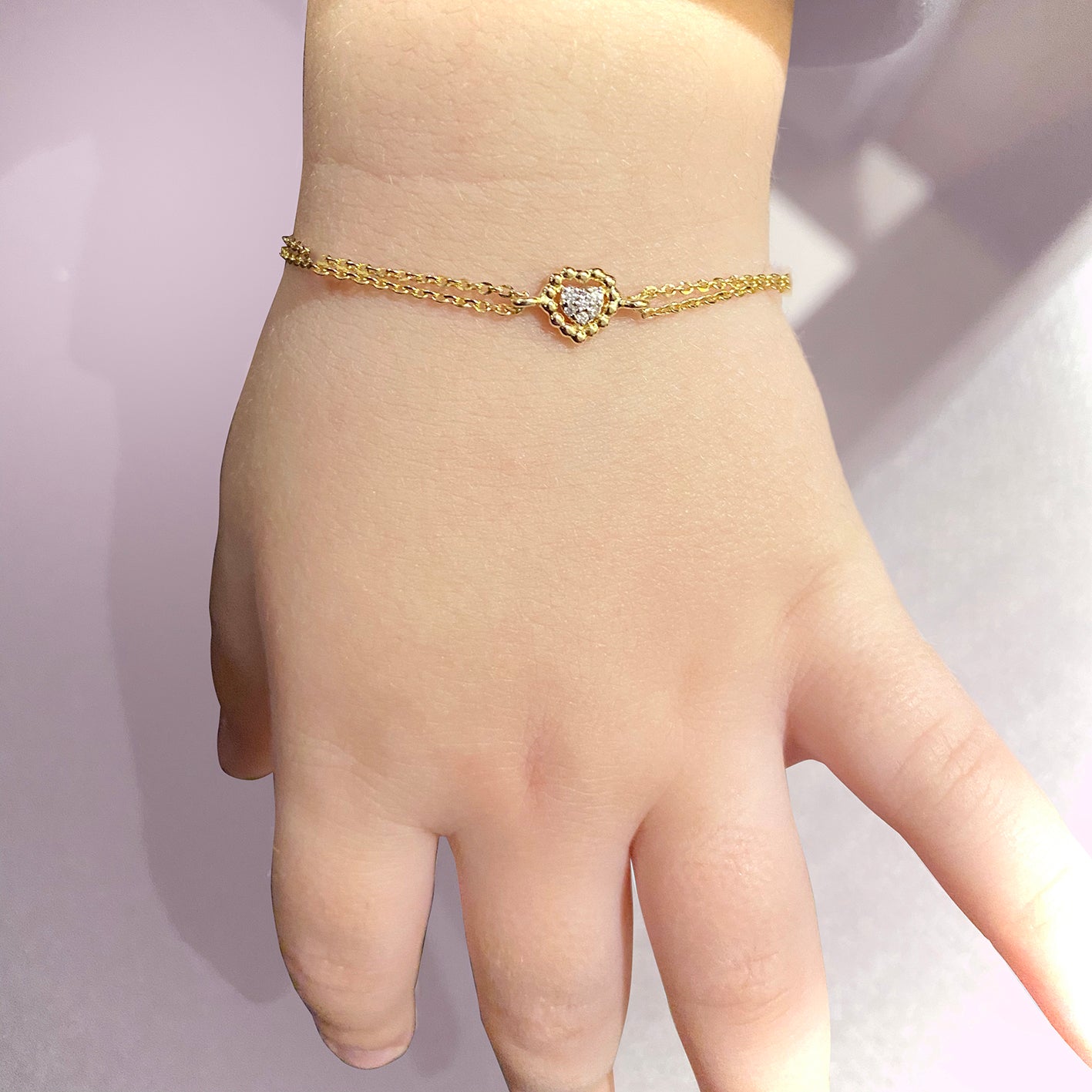 Yellow gold diamond heart bracelet worn on wrist