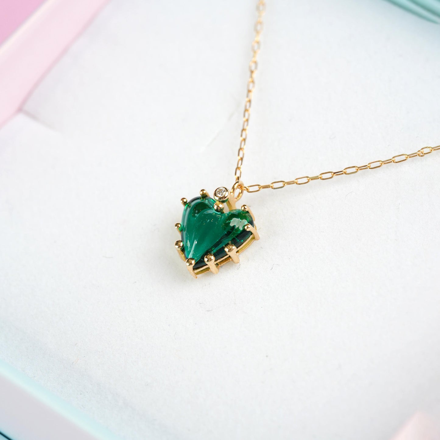 Necklace with a green heart-shaped pendant on a light background