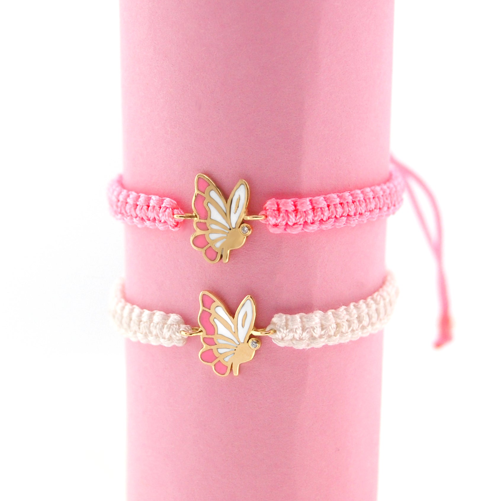 Two butterfly-themed bracelets on a pink background