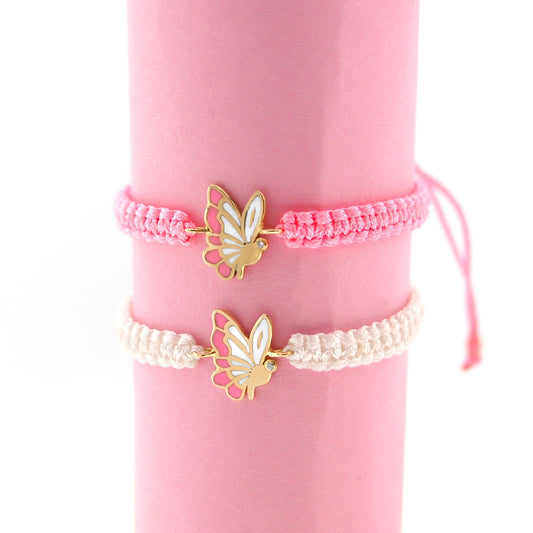 Two butterfly-themed bracelets on a pink background