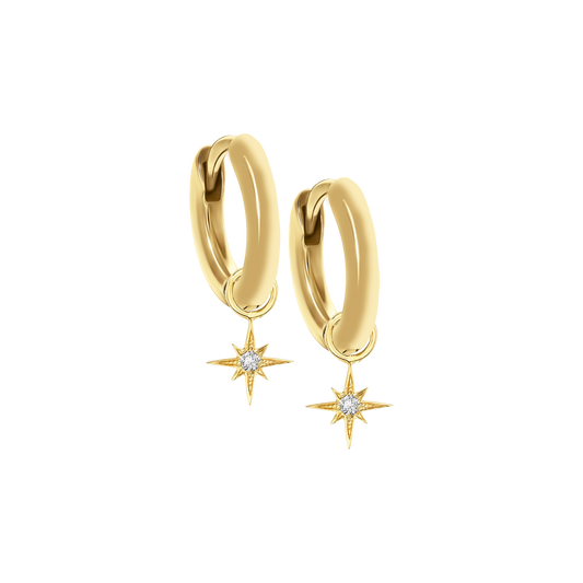 A pair of 18K yellow-gold mini hoop earrings, each hoop suspending a small eight-point star charm set with a single round brilliant-cut diamond at its center, shown side by side on a transparent background.
