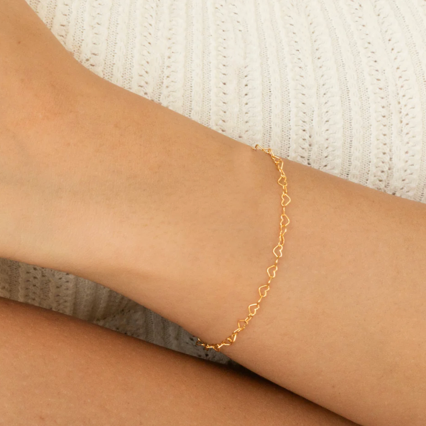 Heart link chain bracelet in yellow gold shown worn