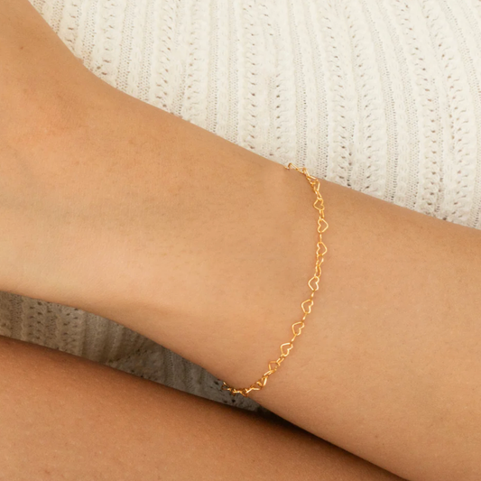 Heart link chain bracelet in yellow gold shown worn